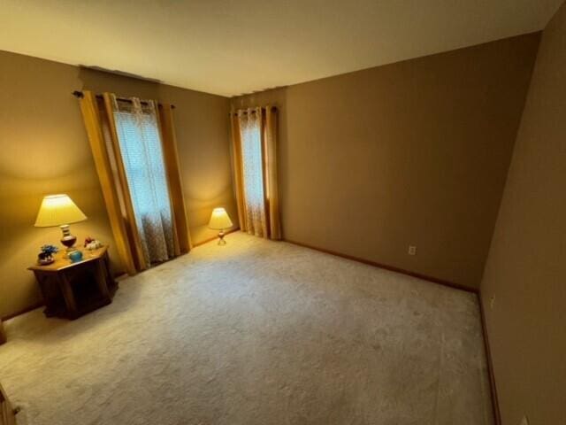 spare room featuring light carpet