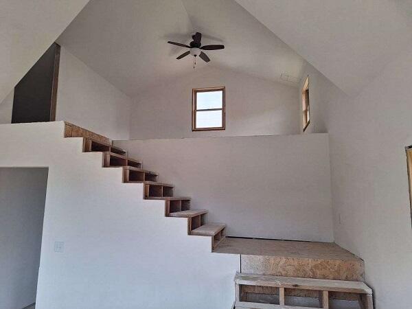 stairway with vaulted ceiling and ceiling fan