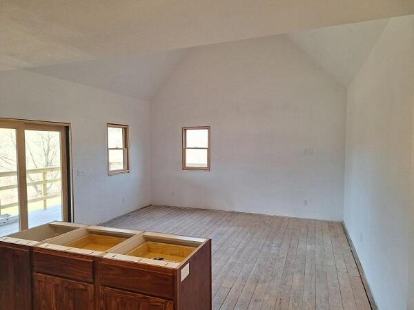 spare room with light hardwood / wood-style floors, a healthy amount of sunlight, and vaulted ceiling