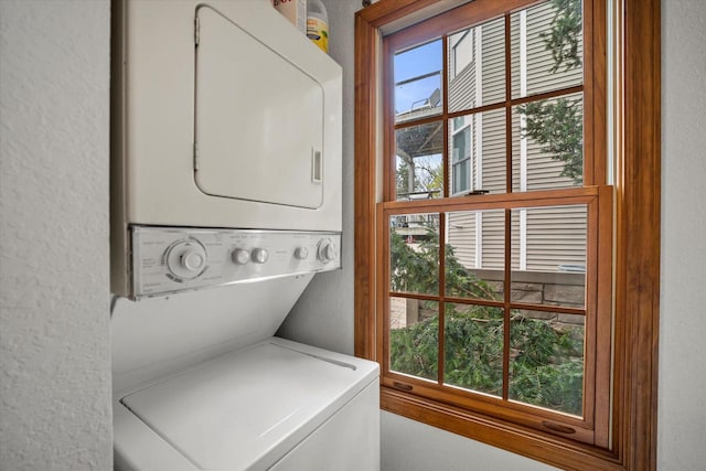 laundry area with plenty of natural light and stacked washer / drying machine