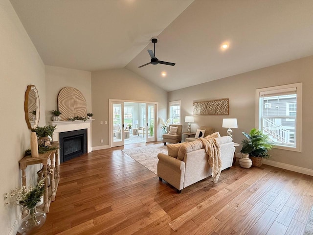 living room with ceiling fan, lofted ceiling, and light hardwood / wood-style flooring