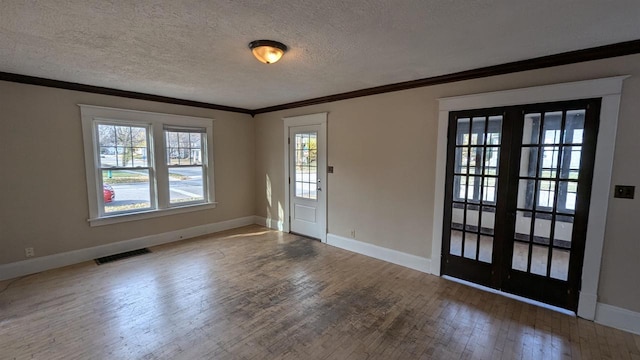 entryway featuring french doors, hardwood / wood-style flooring, a textured ceiling, and ornamental molding