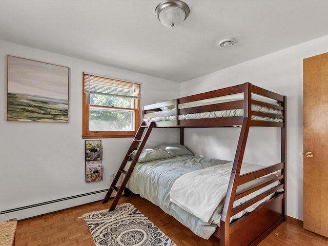 bedroom featuring parquet flooring and a baseboard heating unit