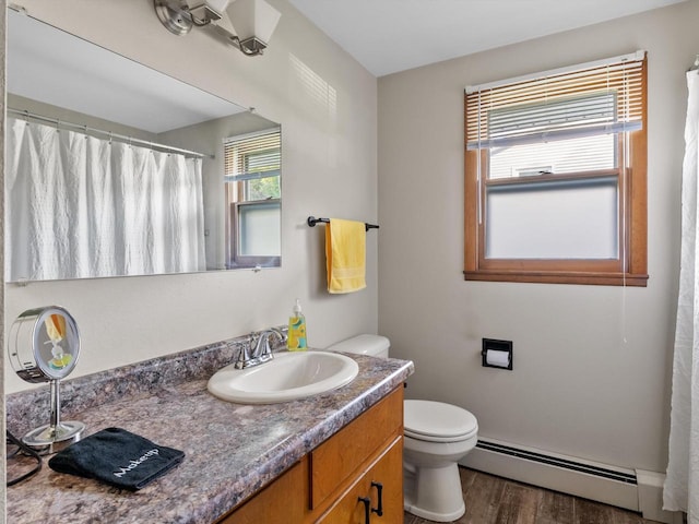 bathroom featuring toilet, a baseboard heating unit, hardwood / wood-style flooring, and vanity