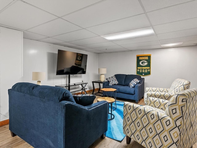 living room with a paneled ceiling and light hardwood / wood-style floors