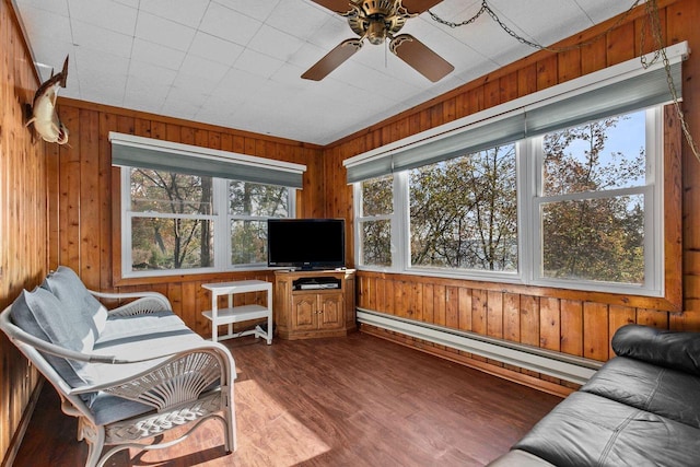 sunroom / solarium with a baseboard heating unit and ceiling fan