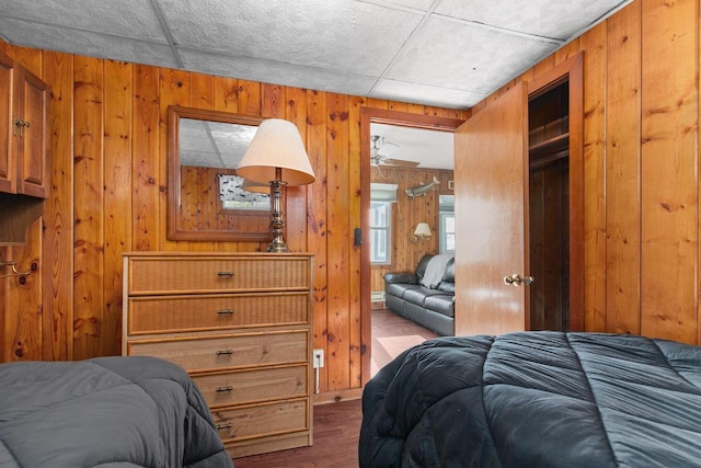 bedroom featuring wood walls and wood-type flooring