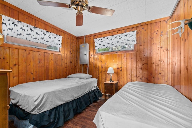 bedroom featuring wooden walls, dark hardwood / wood-style floors, and ceiling fan