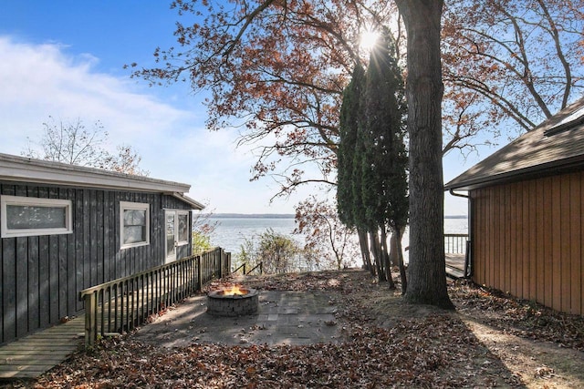 view of yard with a patio area, an outdoor fire pit, and a water view