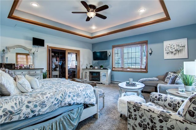 bedroom with ceiling fan, carpet, and a tray ceiling