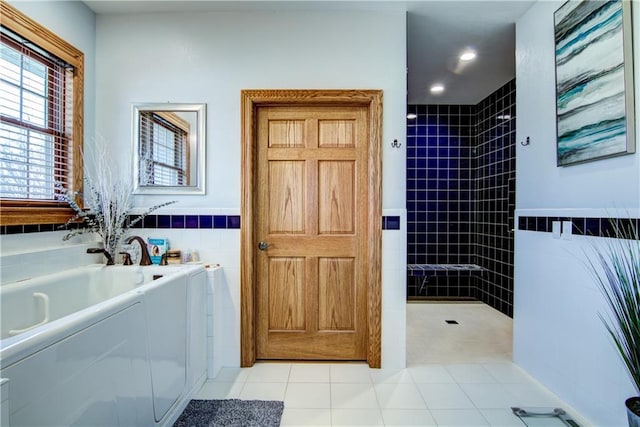 bathroom featuring tile patterned flooring, tile walls, and shower with separate bathtub