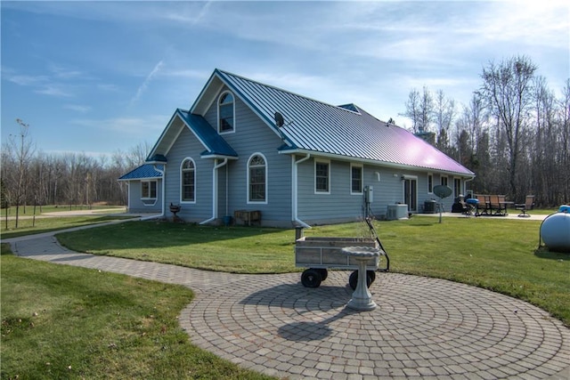 view of front facade with a front yard, cooling unit, and a patio area