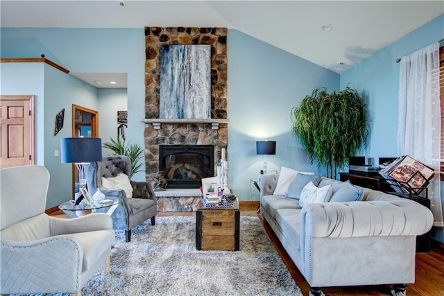 living room with a stone fireplace, vaulted ceiling, and dark hardwood / wood-style floors