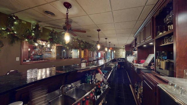 bar featuring tile patterned flooring, sink, decorative light fixtures, a paneled ceiling, and ceiling fan