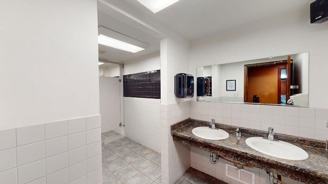 bathroom with tile walls, sink, and tile patterned flooring