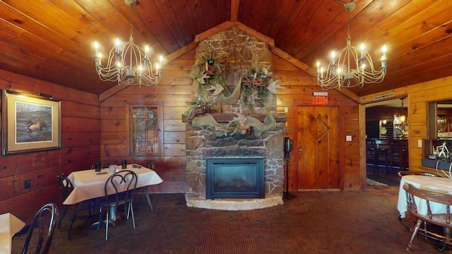 dining area featuring carpet flooring, vaulted ceiling, wooden walls, and a fireplace