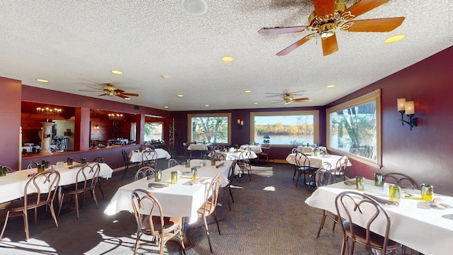 carpeted dining area with ceiling fan and a textured ceiling