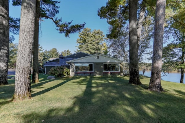 view of front of house featuring a front lawn and a water view