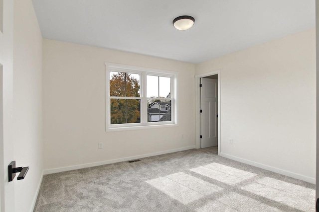 unfurnished room featuring light carpet