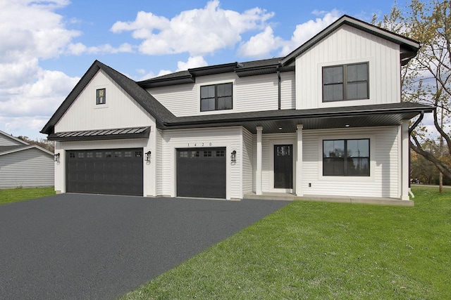 modern inspired farmhouse with a garage and a front lawn