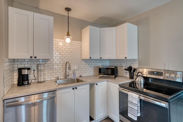 kitchen with white cabinetry, sink, decorative backsplash, decorative light fixtures, and stainless steel appliances