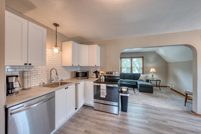 kitchen featuring sink, white cabinets, light hardwood / wood-style floors, and appliances with stainless steel finishes