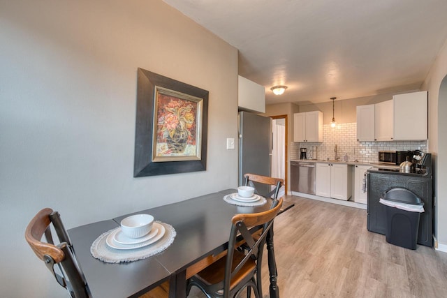 dining room with light hardwood / wood-style flooring and sink