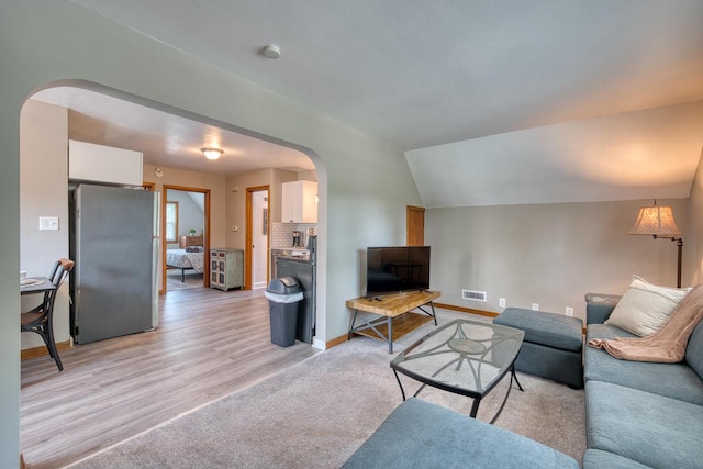 living room featuring light hardwood / wood-style flooring and lofted ceiling