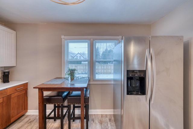 kitchen featuring stainless steel fridge and light hardwood / wood-style floors