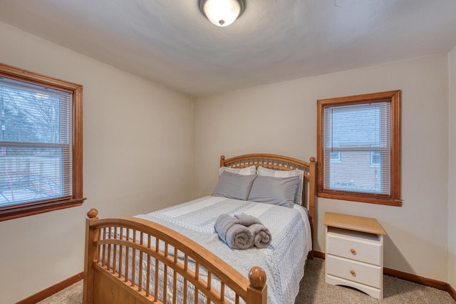 bedroom with light carpet and multiple windows