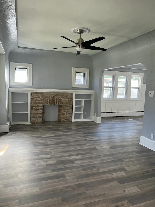 unfurnished living room with ceiling fan, built in features, and dark hardwood / wood-style floors