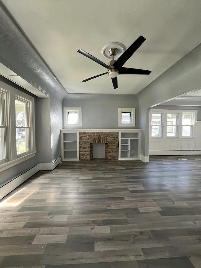 unfurnished living room with ceiling fan, a fireplace, and dark hardwood / wood-style floors