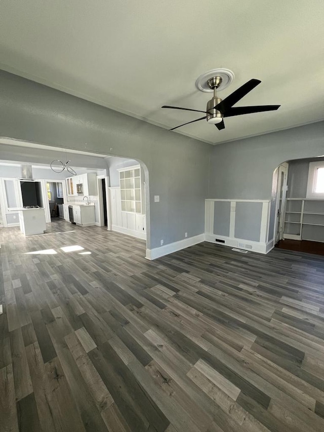 unfurnished living room featuring ceiling fan and dark hardwood / wood-style flooring