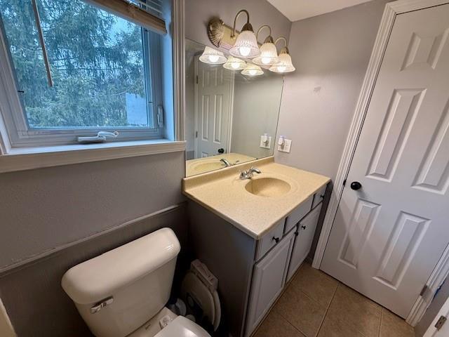 414 8th St, Baraboo, WI 53913 - bathroom with an inviting chandelier, tile patterned floors, vanity, and toilet