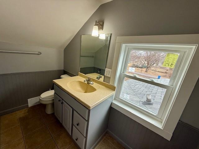 414 8th St, Baraboo, WI 53913 - half bath featuring vanity, tile patterned flooring, lofted ceiling, and toilet