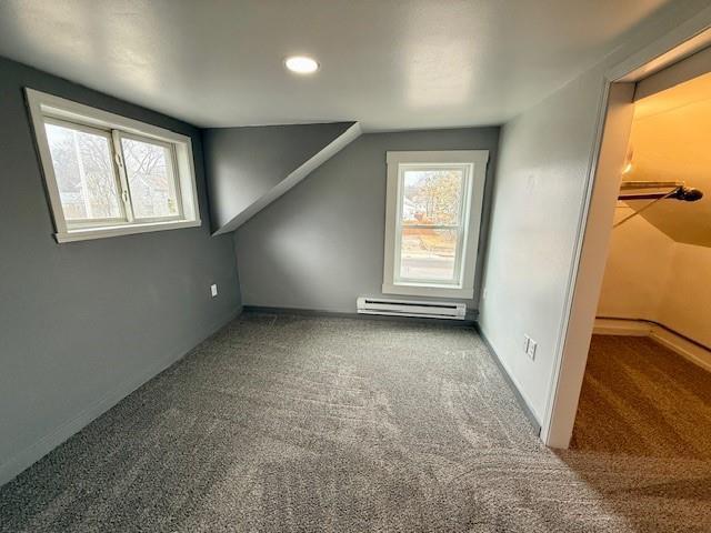 414 8th St, Baraboo, WI 53913 - additional living space featuring vaulted ceiling, carpet, a baseboard heating unit, and a wealth of natural light