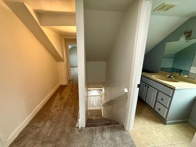 414 8th St, Baraboo, WI 53913 - stairway with visible vents, baseboards, tile patterned floors, lofted ceiling, and carpet