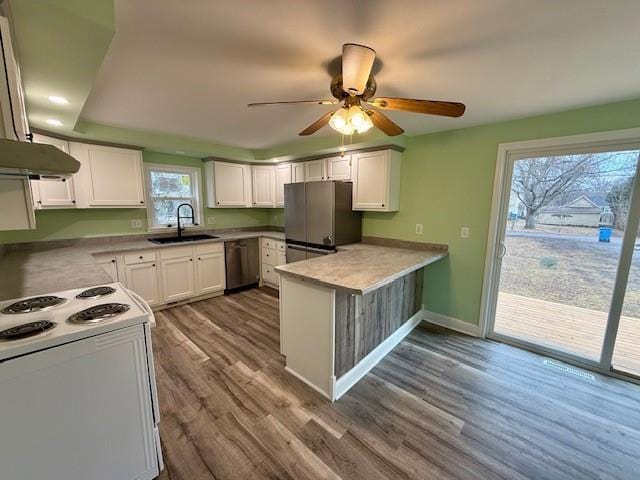 414 8th St, Baraboo, WI 53913 - kitchen with ceiling fan, appliances with stainless steel finishes, a sink, a peninsula, and dark wood-style floors