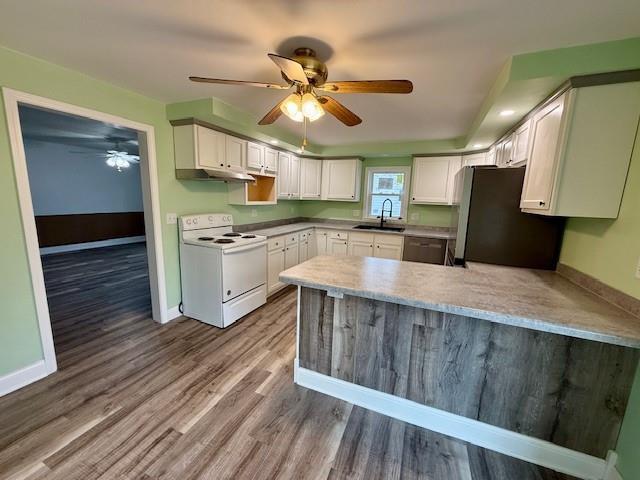 414 8th St, Baraboo, WI 53913 - kitchen with white range with electric cooktop, baseboards, freestanding refrigerator, a peninsula, and black dishwasher