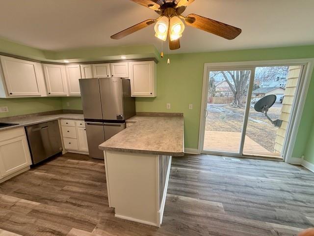 414 8th St, Baraboo, WI 53913 - kitchen featuring dark wood finished floors, a peninsula, white cabinets, and stainless steel appliances