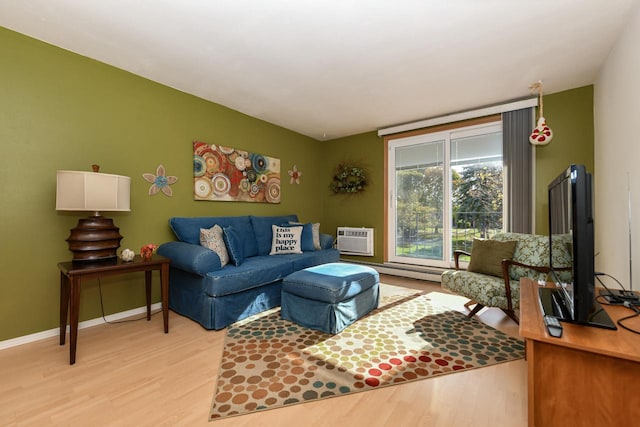 living room with a wall mounted AC and light hardwood / wood-style flooring