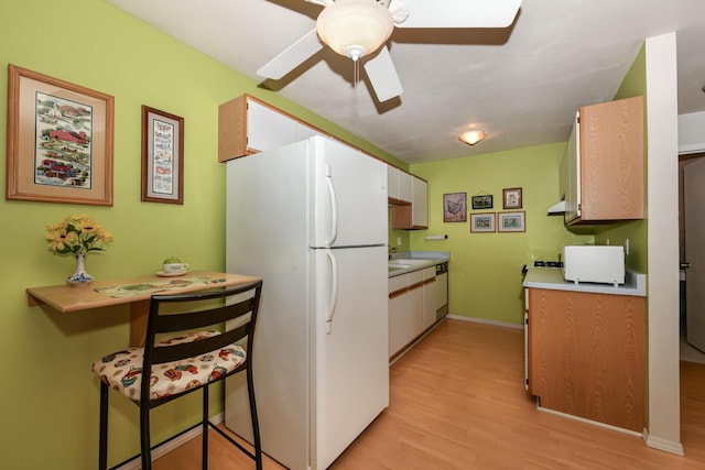 kitchen with white appliances, white cabinets, light hardwood / wood-style flooring, ceiling fan, and a breakfast bar area