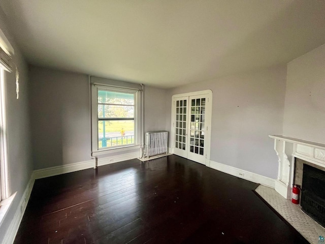 unfurnished living room with radiator, french doors, and dark hardwood / wood-style floors