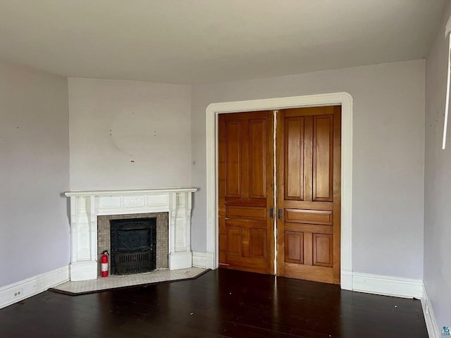 unfurnished living room with dark hardwood / wood-style flooring and a fireplace