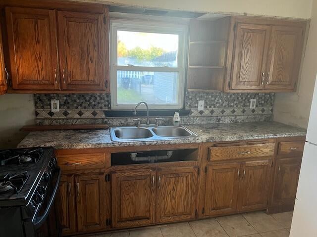 kitchen with black range oven, sink, decorative backsplash, and light tile patterned floors