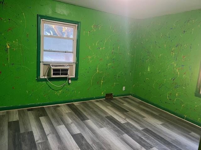 empty room featuring cooling unit and hardwood / wood-style flooring