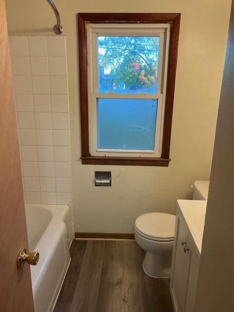 full bathroom with vanity, washtub / shower combination, hardwood / wood-style flooring, and toilet