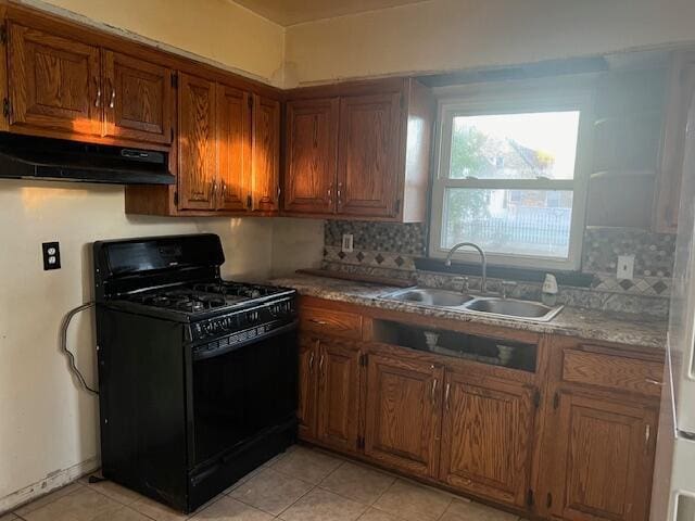 kitchen with sink, backsplash, light stone counters, black range with gas cooktop, and light tile patterned floors