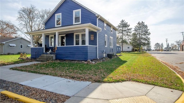 bungalow with covered porch, a front yard, and central AC unit