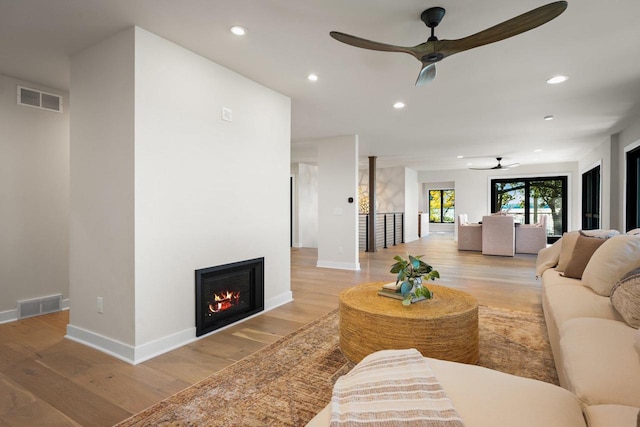 living room with ceiling fan and light hardwood / wood-style floors